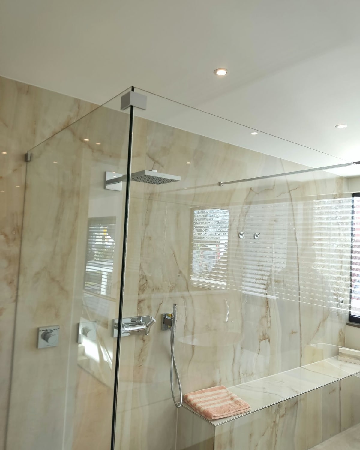 Bad mit Glasdusche und Wandfliesen in Steinoptik aus einem unserer Projekte