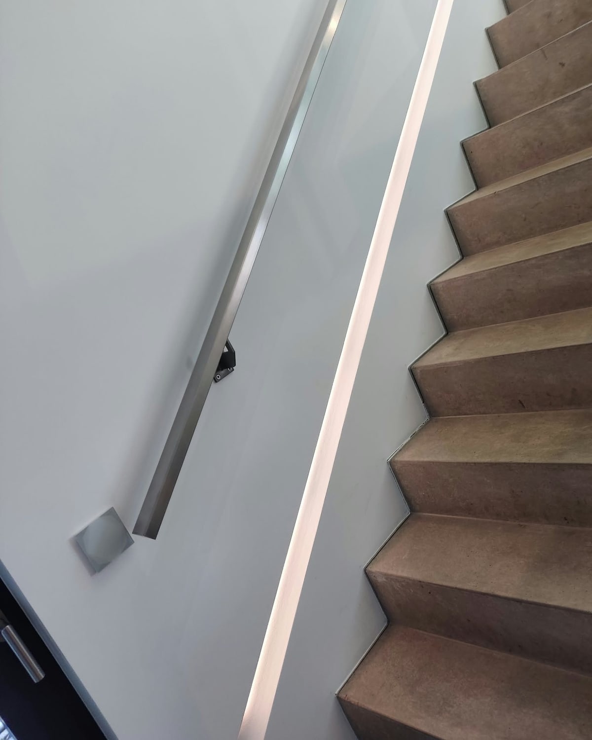 Treppe mit beleuchtetem Handlauf